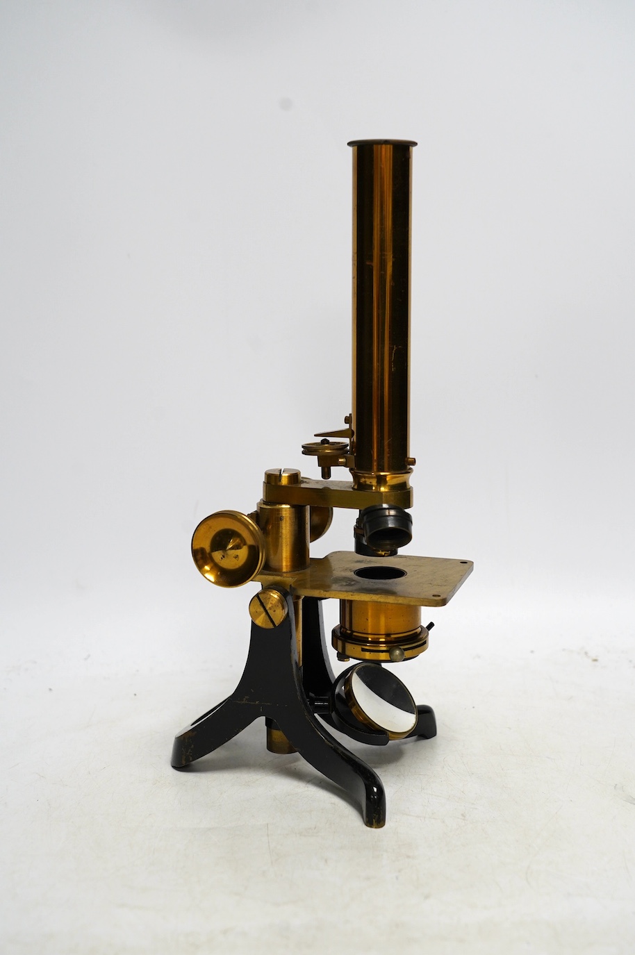 An unmarked late 19th century monocular brass microscope, in a fitted mahogany case with alternative lenses, a drawer for slides and other accessories, case 39cm high. Condition - fair to good